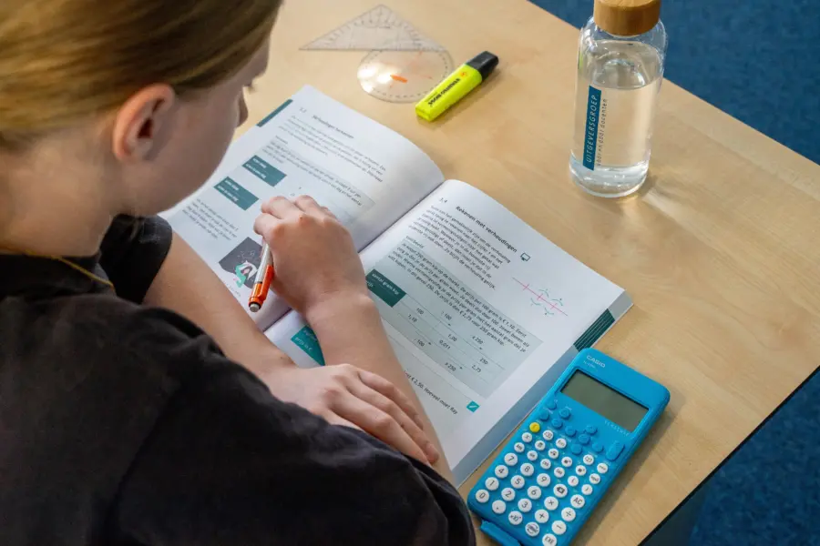 Leerling aan tafel met rekenboek